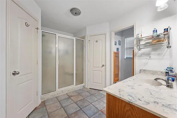 a spacious bathroom with a granite countertop sink and a mirror