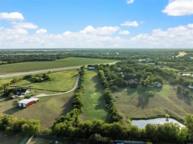 an aerial view of residential houses with outdoor space and lake view