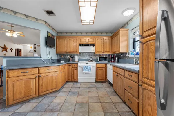 a kitchen with stainless steel appliances granite countertop a sink counter space cabinets and a large window