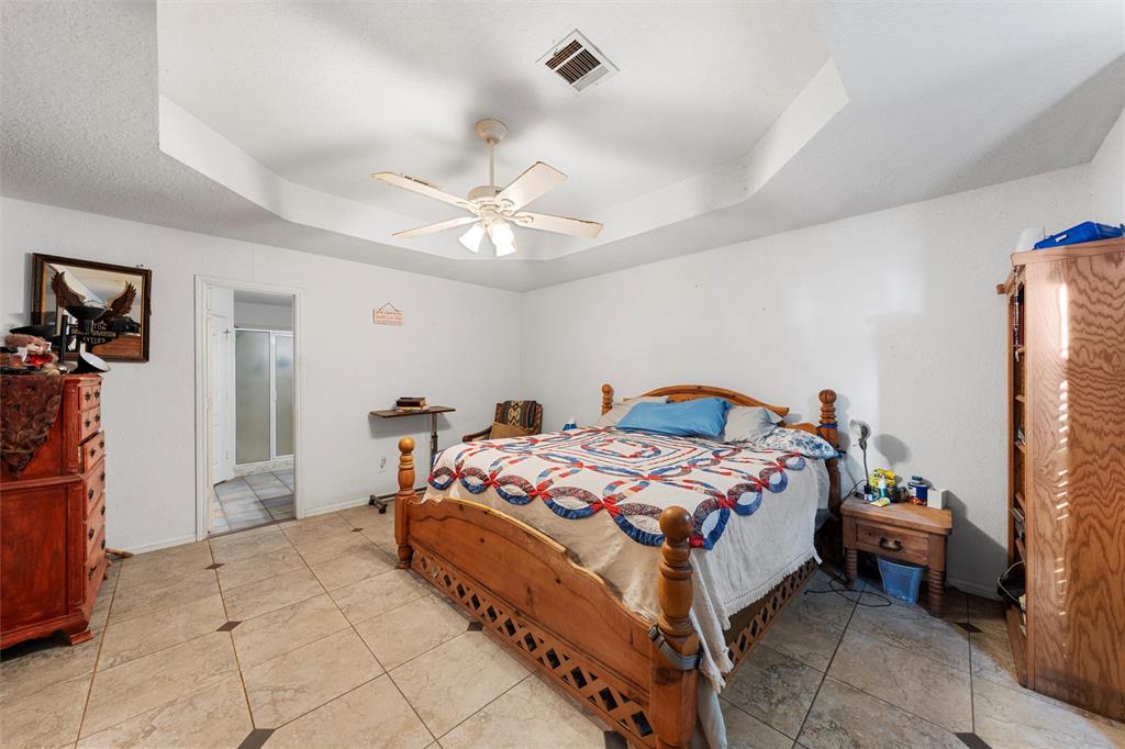 10829 China Spring Road Waco, TX 76708 - Photo 10 of 27 a bedroom with a bed and a chandelier