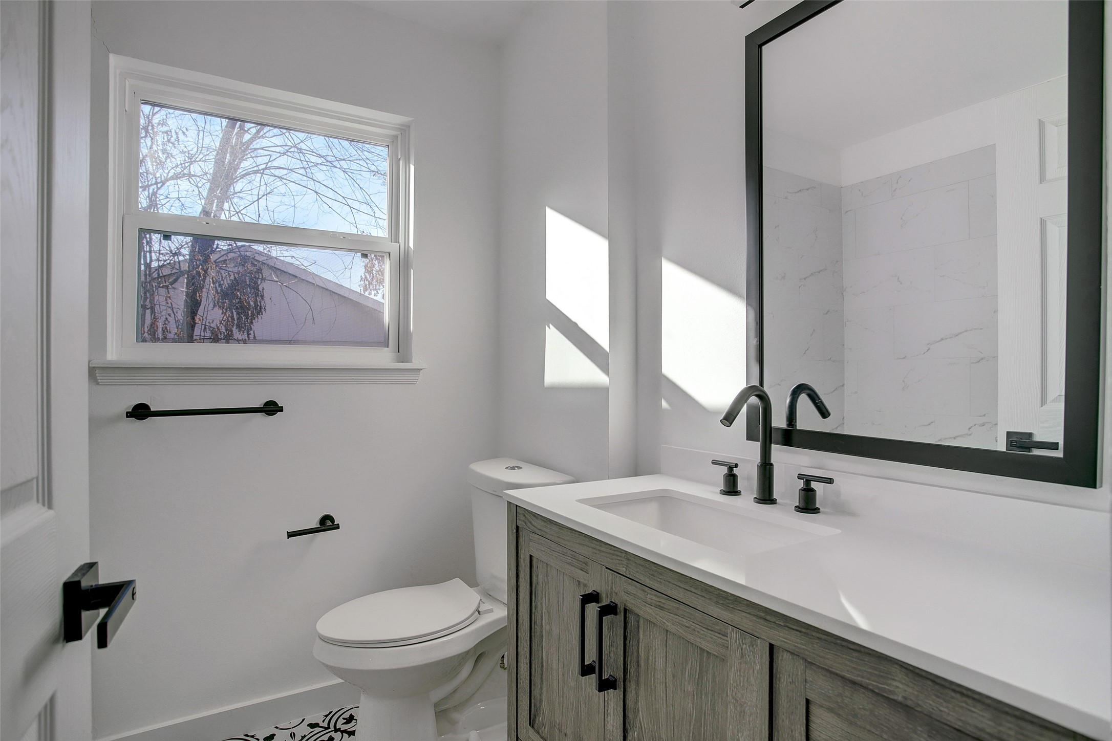 5531 Jason Street Houston, TX 77096 - Photo 5 of 8 a bathroom with a toilet a sink a mirror and a window