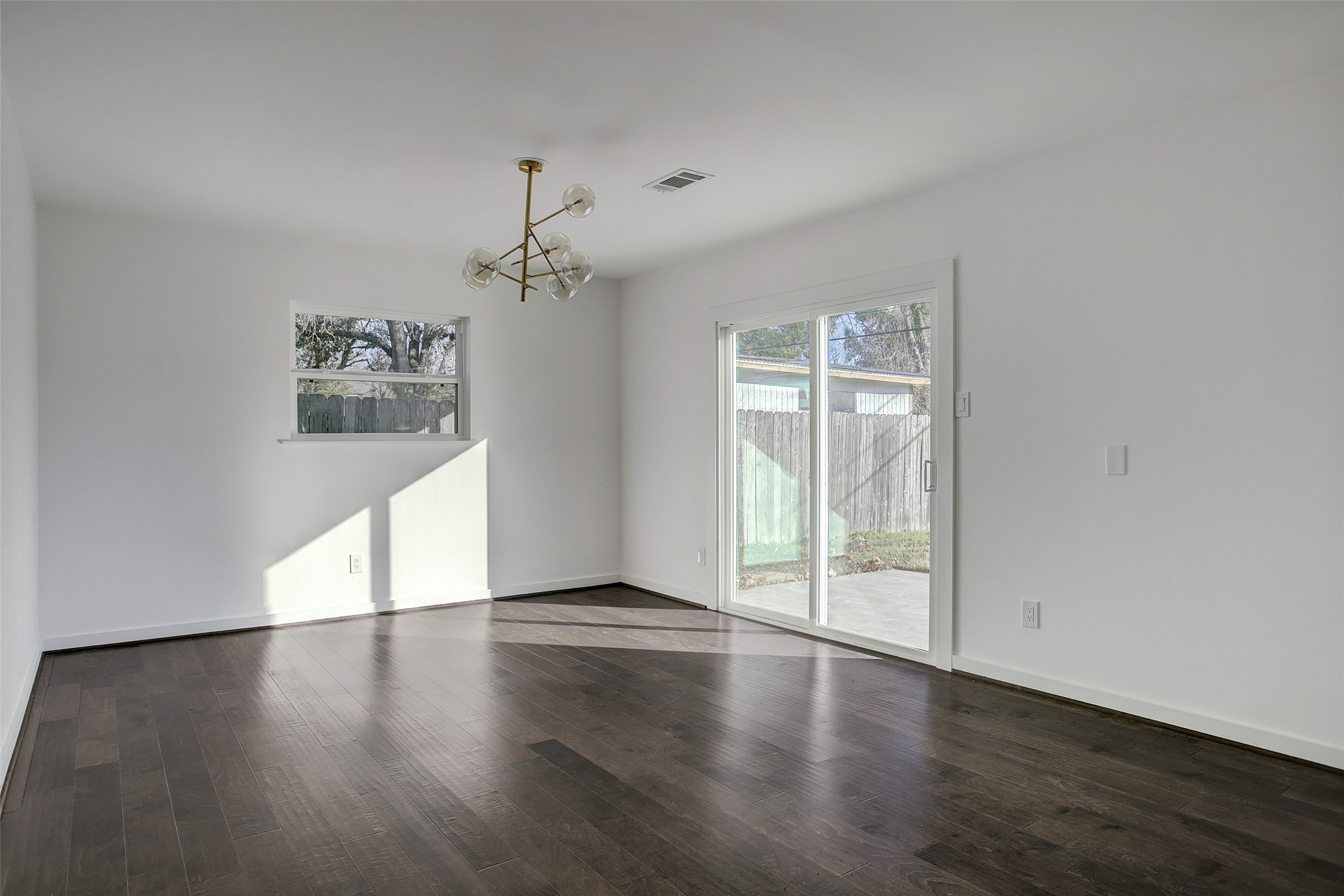 5531 Jason Street Houston, TX 77096 - Photo 8 of 8 an empty room with wooden floor chandelier and windows