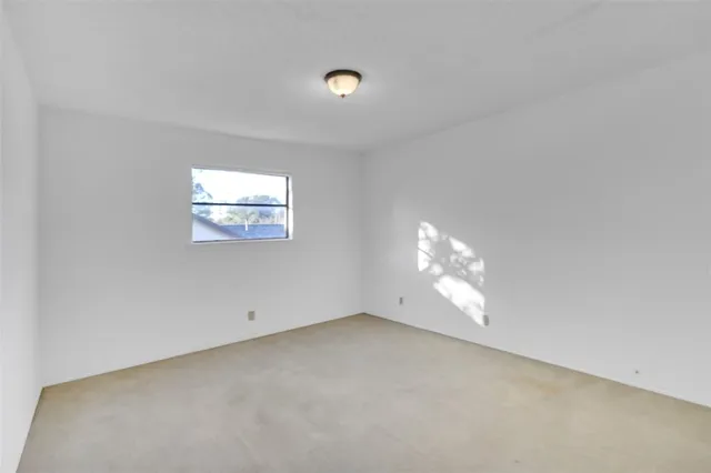 an empty room with windows and white walls