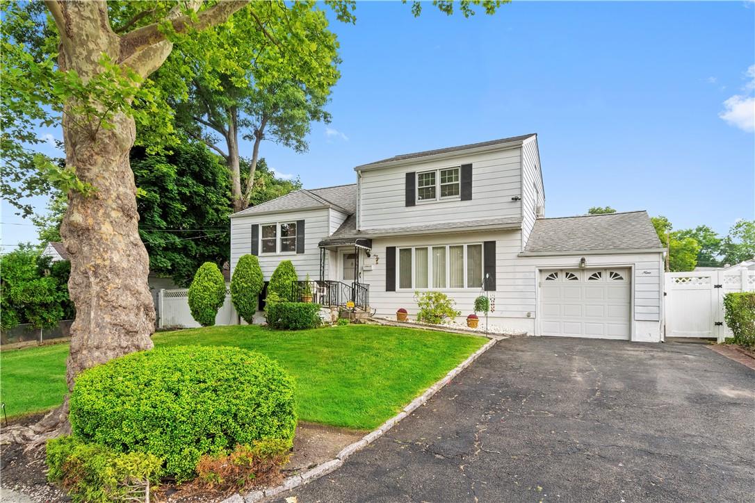 View of front of home featuring a garage and a front yard