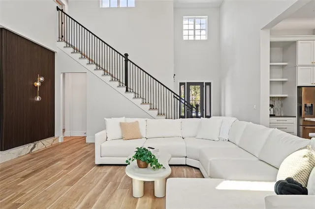 a white kitchen with stainless steel appliances kitchen island granite countertop a stove and a white refrigerator with wooden floor