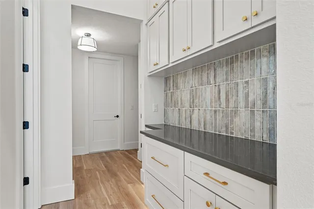 a view of a room with wooden floor and a ceiling fan