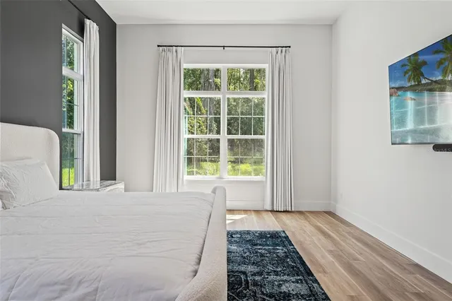 a kitchen with stainless steel appliances granite countertop a stove a sink dishwasher a refrigerator and white cabinets with wooden floor