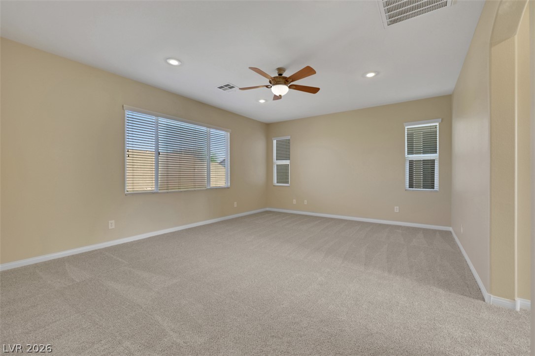 10328 Hawk Ravine Street Las Vegas, NV 89178 - Photo 37 of 55 A spacious room offers comfortable carpeting, recessed lighting, and a cooling ceiling fan.