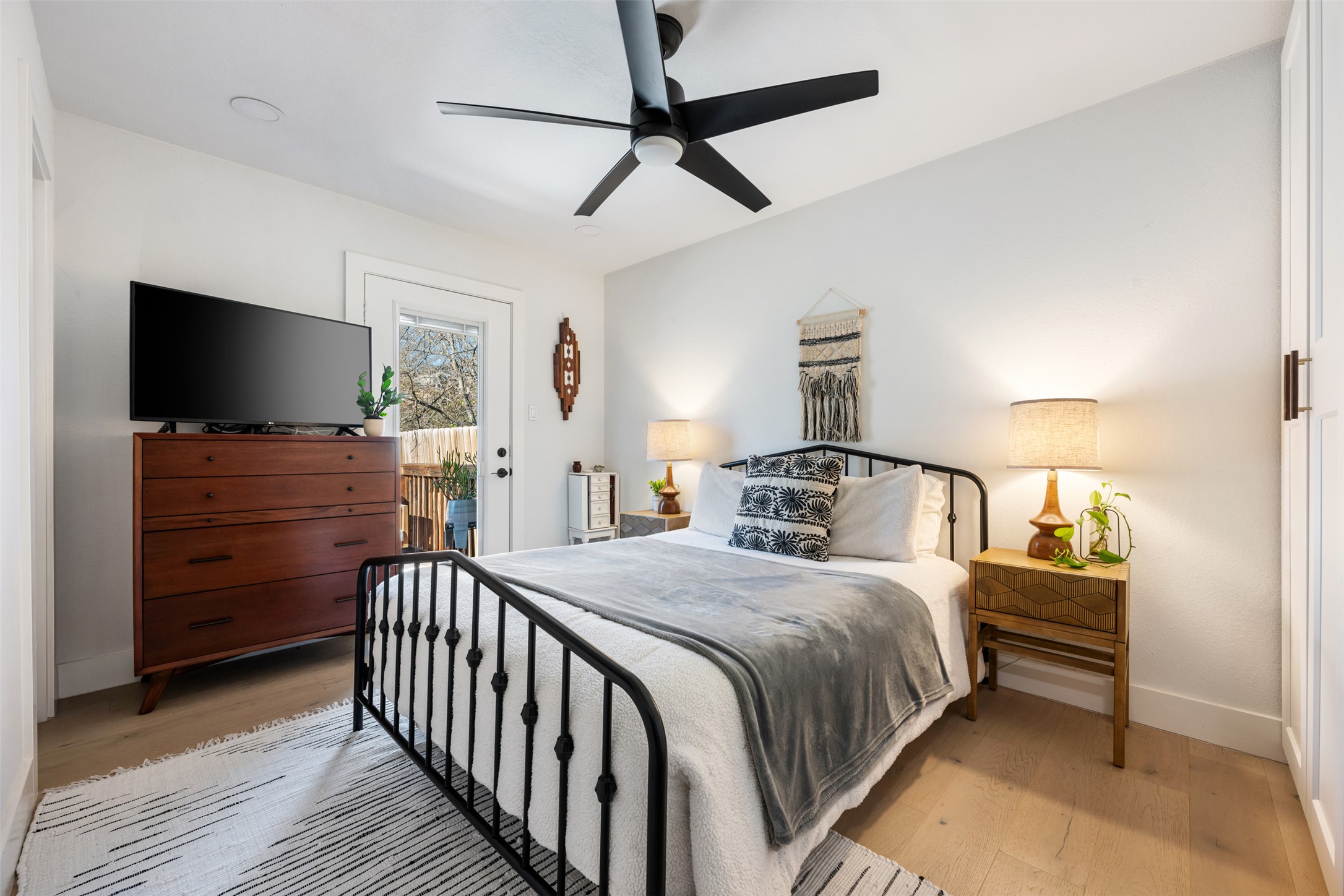 1616 Webberville Road, Unit A Austin, TX 78721 - Photo 12 of 35 Bedroom featuring a ceiling fan, light wood-style floors, and access to outside