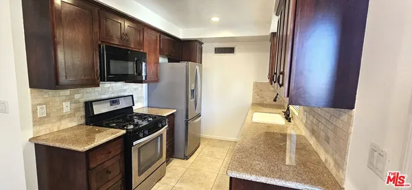 a kitchen with a stove a refrigerator and a microwave