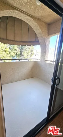 a view of empty room with wooden floor and window