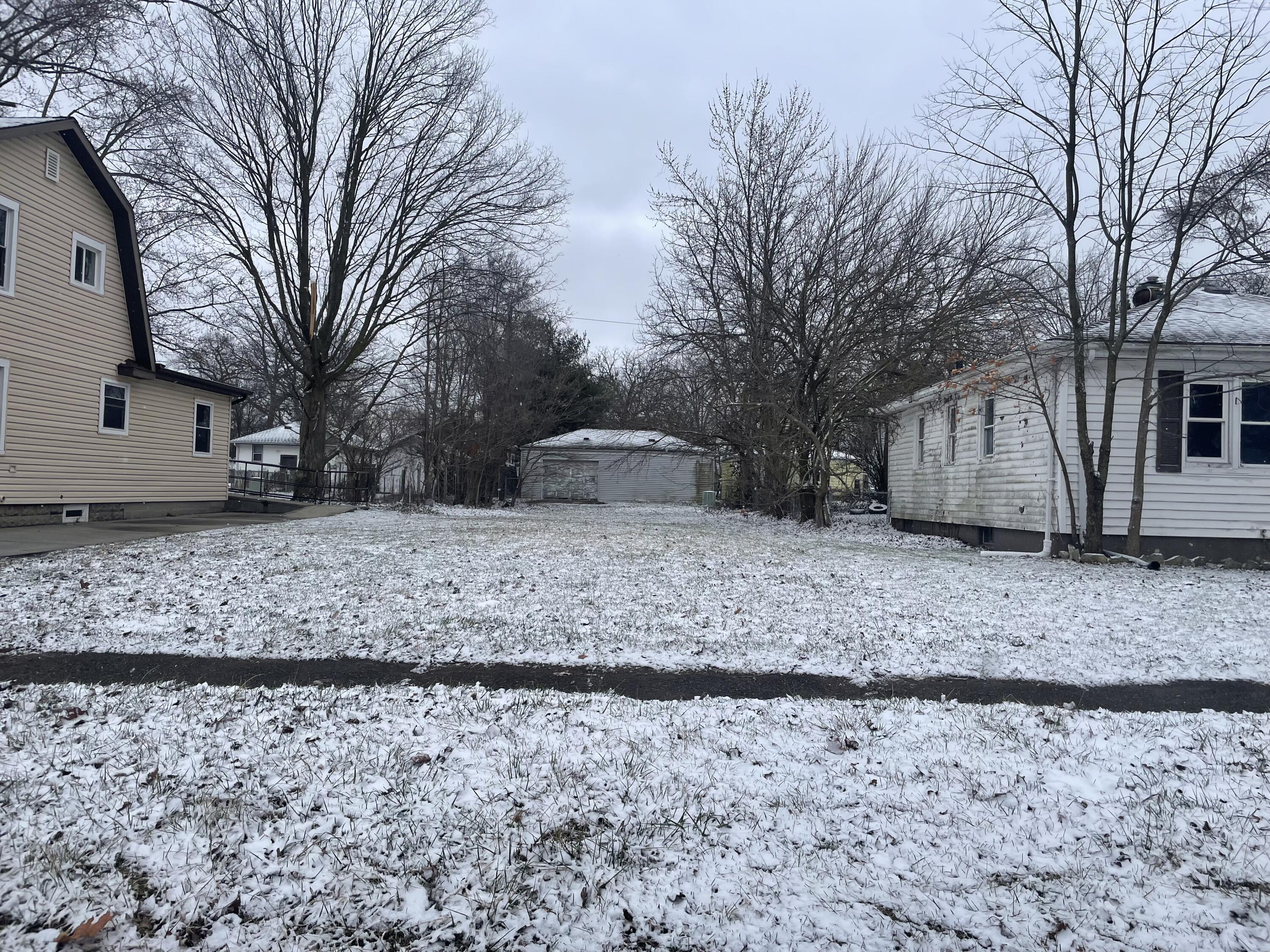a view of a yard with a house covered with snow