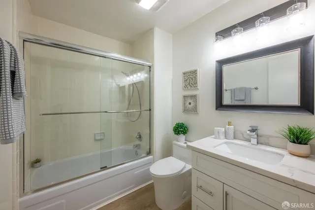 a bathroom with a granite countertop sink toilet and shower