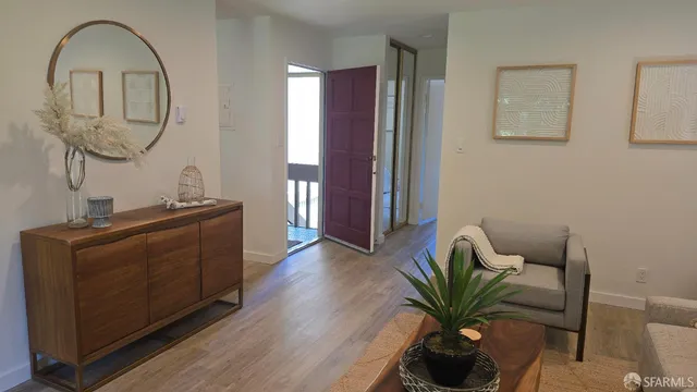 a living room with furniture a mirror and a potted plant