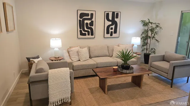 a living room with furniture and paintings on the wall
