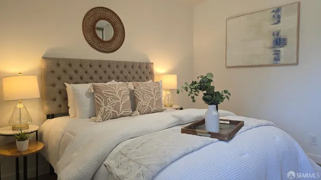 a bedroom with a bed and a lamp on dresser