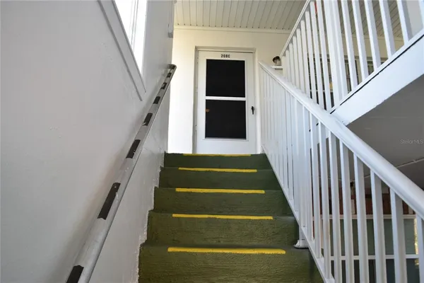 a view of staircase with wooden floor and white walls