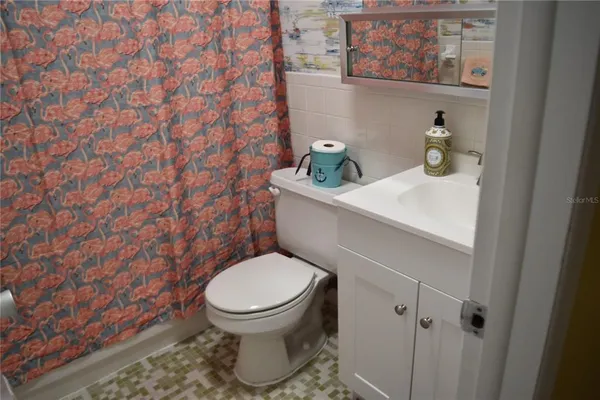 a bathroom with a shower curtain and a flat screen tv