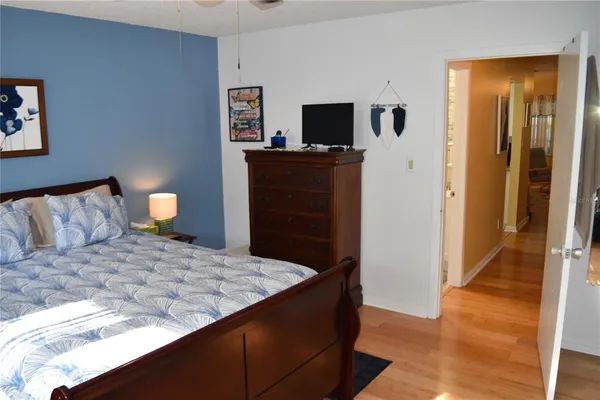 a bedroom with a bed and a flat tv screen on dresser