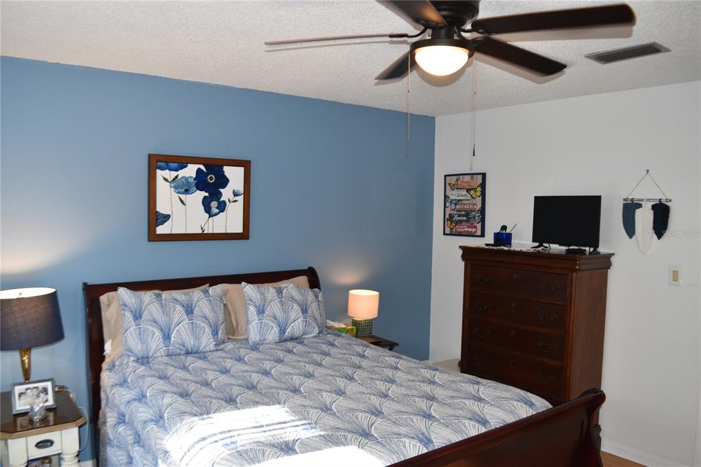 4746 Azalea Drive, Unit 208C New Port Richey, FL 34652 - Photo 32 of 56 a bedroom with a bed and a flat tv screen on dresser
