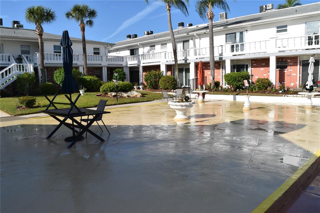 4746 Azalea Drive, Unit 208C New Port Richey, FL 34652 - Photo 37 of 56 a view of a swimming pool with a patio