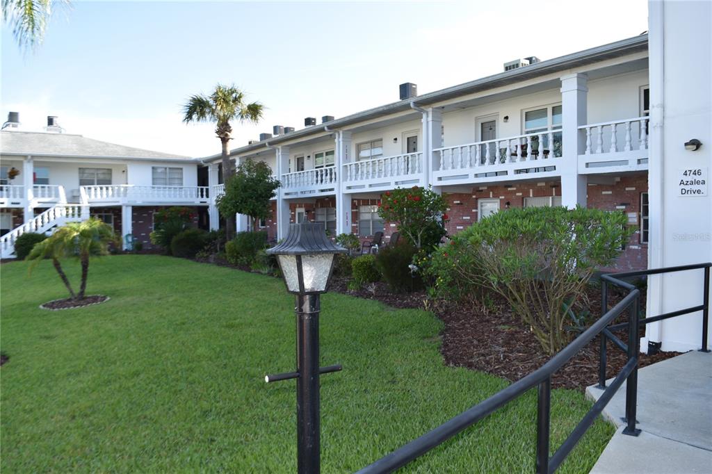 4746 Azalea Drive, Unit 208C New Port Richey, FL 34652 - Photo 43 of 56 a front view of a house with garden