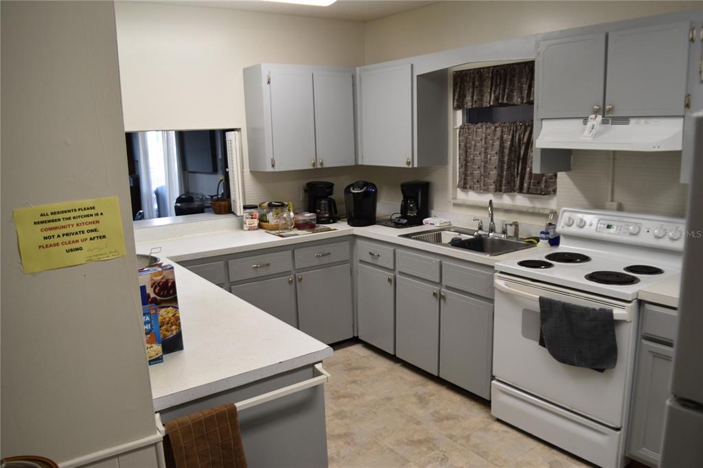 4746 Azalea Drive, Unit 208C New Port Richey, FL 34652 - Photo 51 of 56 a kitchen with a stove a sink and a refrigerator