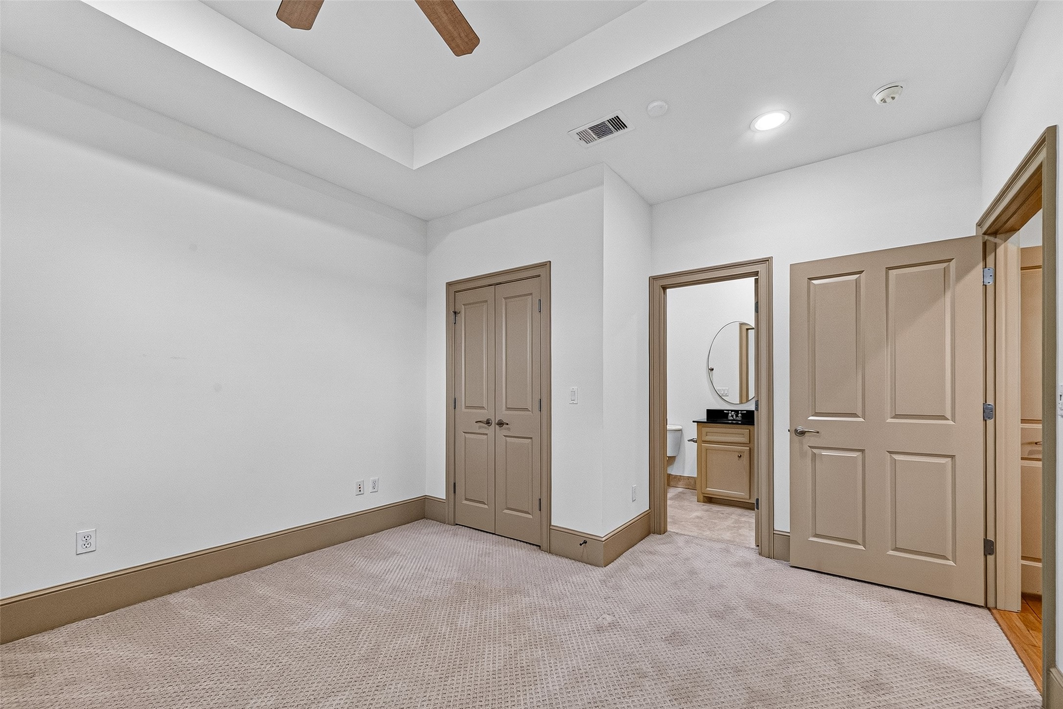 2034 Colquitt Street, Unit A Houston, TX 77098 - Photo 34 of 41 This 3rd floor ensuite bedroom features a cozy, carpeted space with a tray ceiling and recessed lighting. It includes two windows with wooden shutters and a ceiling fan, offering a comfortable and inviting atmosphere.