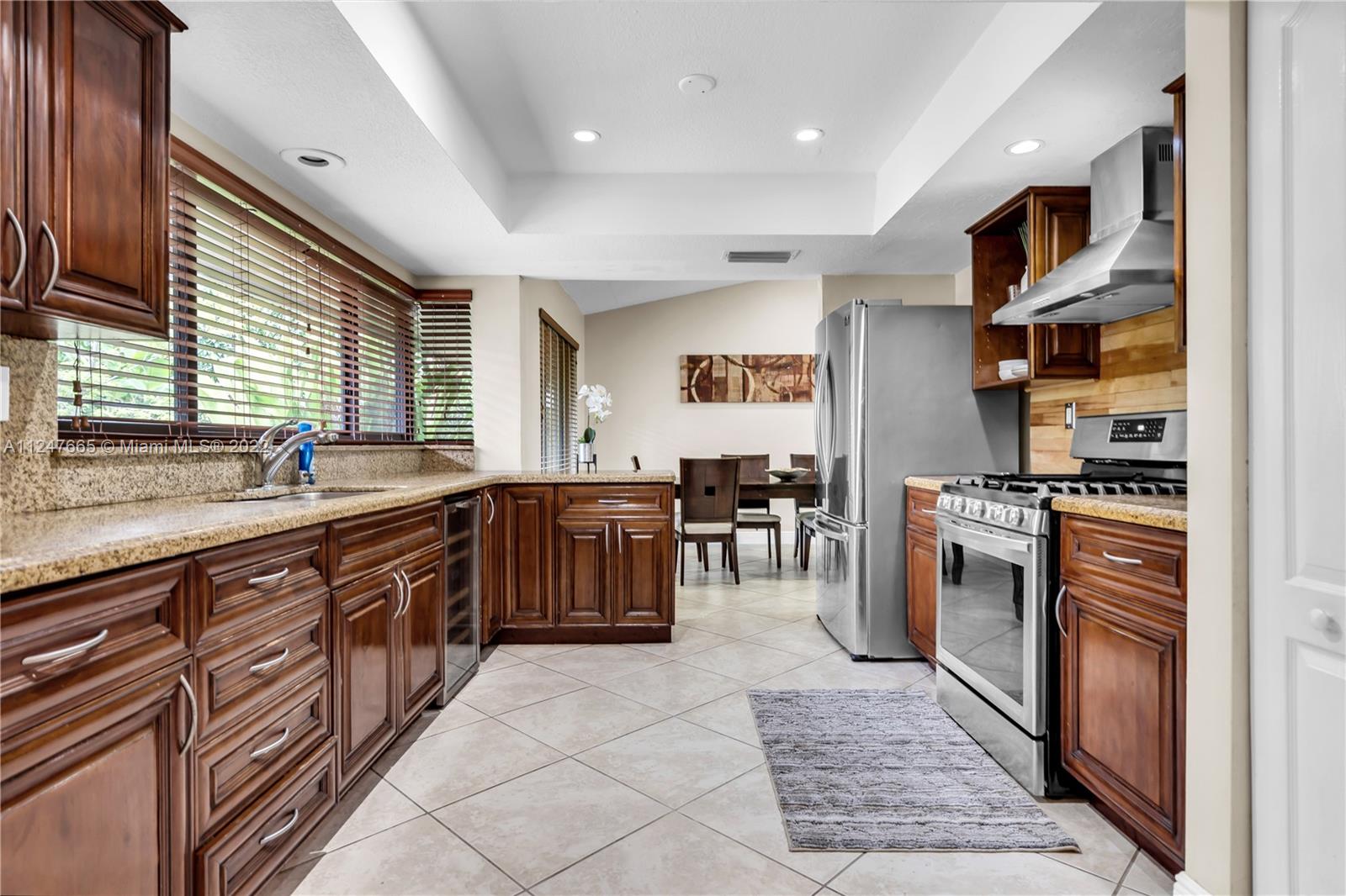 11809 Southwest 95th Street Miami, FL 33186 - Photo 13 of 25 a kitchen with stainless steel appliances granite countertop a sink counter space cabinets and a large window