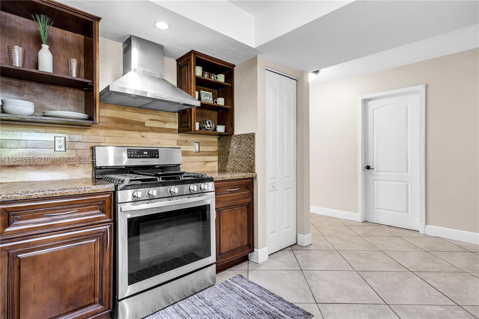 11809 Southwest 95th Street Miami, FL 33186 - Photo 14 of 25 a kitchen with stainless steel appliances granite countertop a stove and a refrigerator