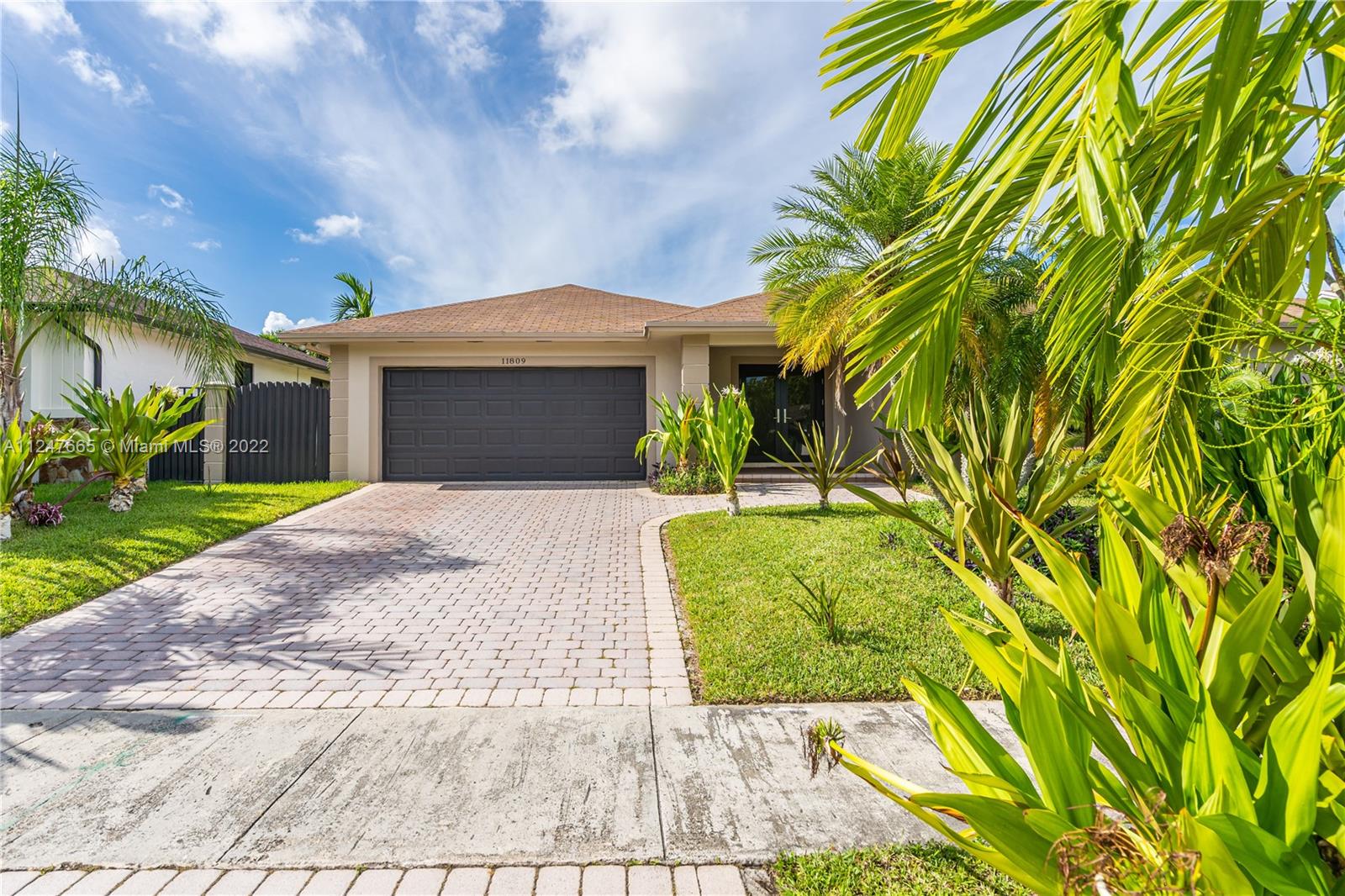 11809 Southwest 95th Street Miami, FL 33186 - Photo 2 of 25 a front view of a house with a garden and yard
