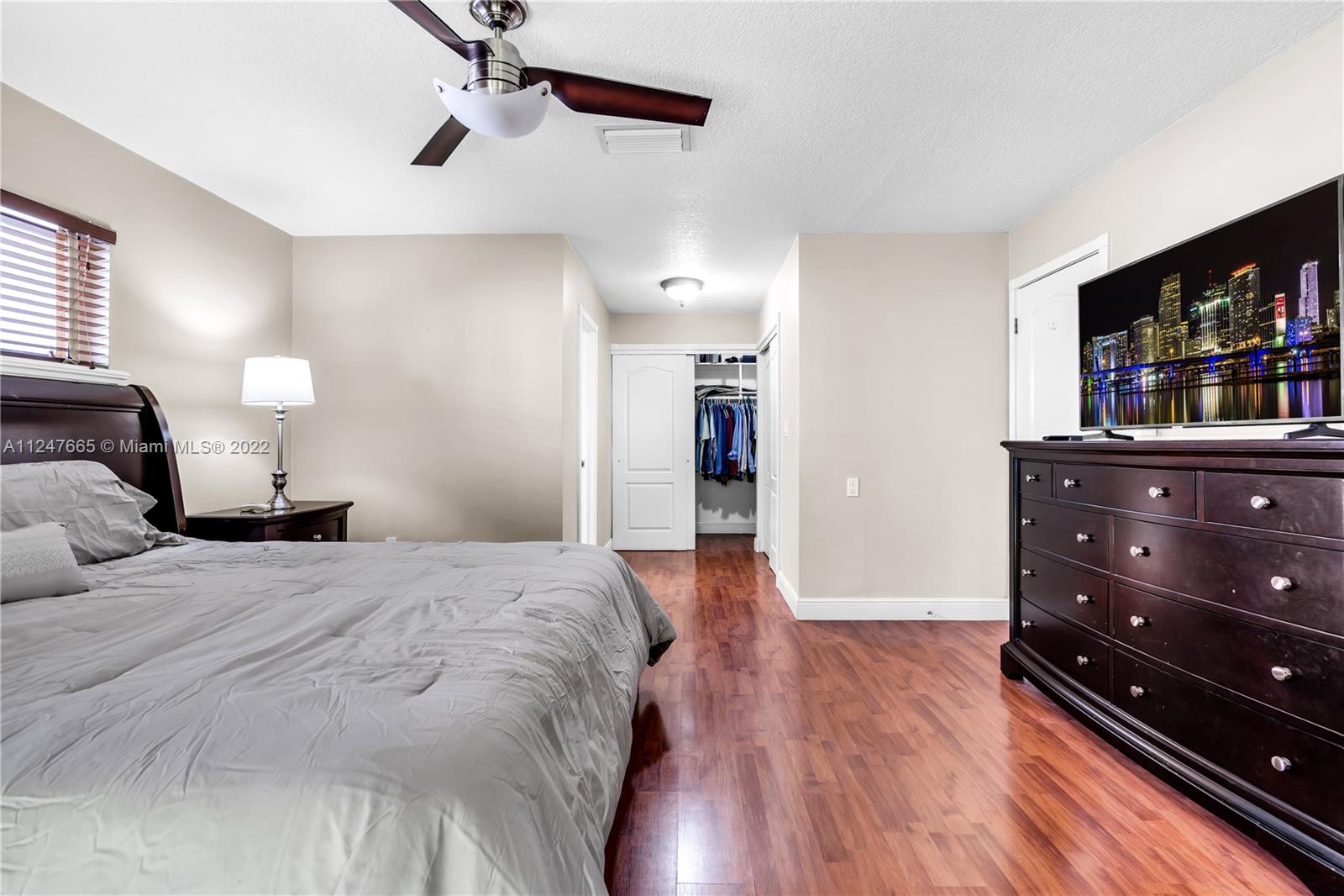 11809 Southwest 95th Street Miami, FL 33186 - Photo 22 of 25 a spacious bedroom with a bed and a book shelf
