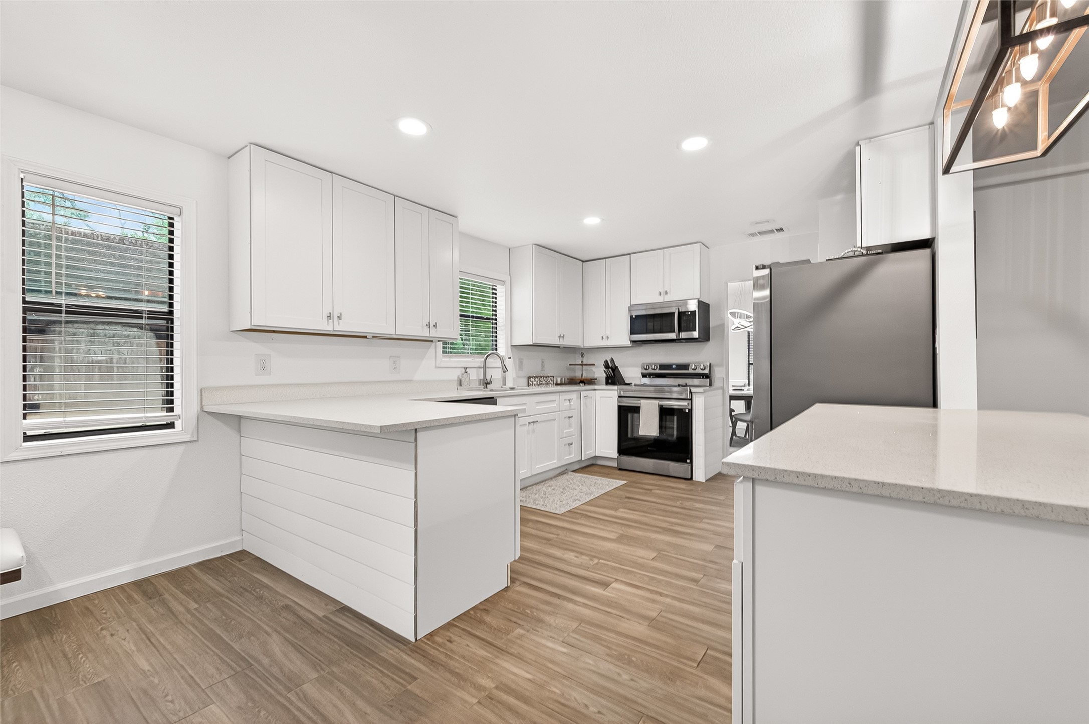 548 Brandon Road Conroe, TX 77302 - Photo 13 of 37 Modern white chef's kitchen features stylish cabinetry and hardware, stainless steel appliances, and a clean neutral design