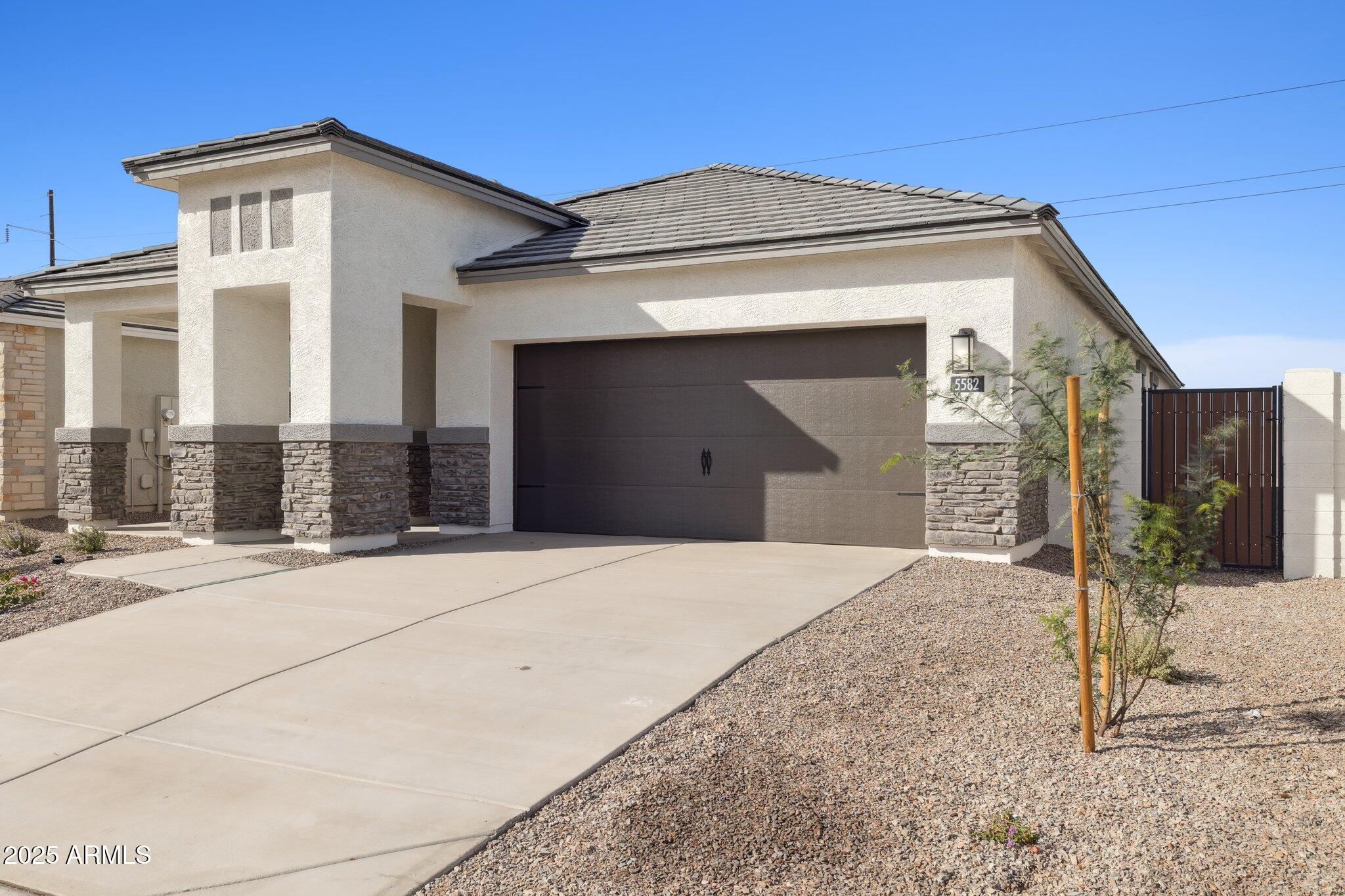 25453 West Fraktur Road Buckeye, AZ 85326 - Photo 2 of 18 a view of a house with a small yard and potted plants