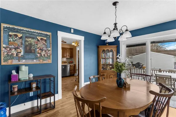 a dining room with furniture a chandelier and wooden floor