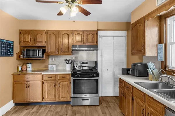 a kitchen with stainless steel appliances granite countertop a refrigerator a sink dishwasher a stove and a microwave oven with cabinets