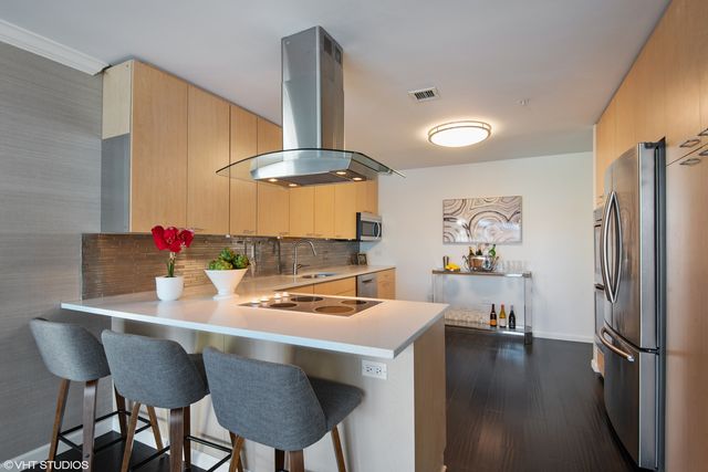 a kitchen with stainless steel appliances a table chairs and stove
