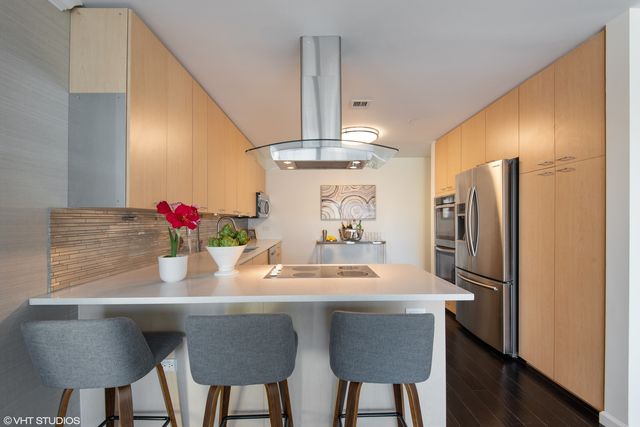 a kitchen with stainless steel appliances granite countertop a kitchen island a stove a table and chairs