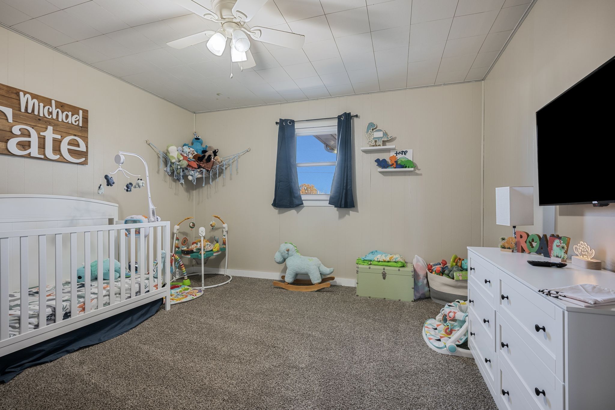3205 Sylvia Road Dickson, TN 37055 - Photo 17 of 26 a bedroom with a bed and flat tv screen on the dresser