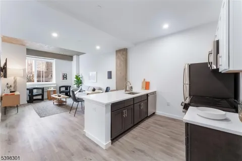 a kitchen with a sink stove and wooden floor