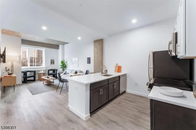 a kitchen with a sink stove and wooden floor