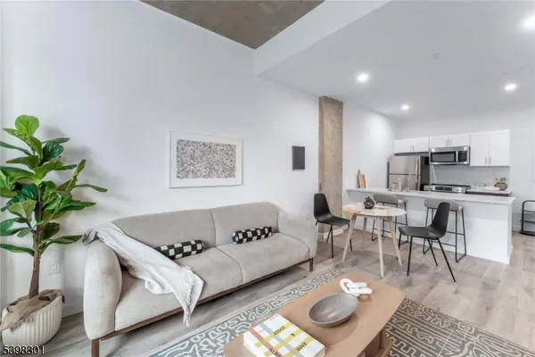 a living room with furniture and a dining table with kitchen view