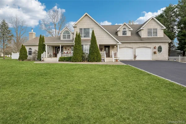 a front view of a house with a garden and trees