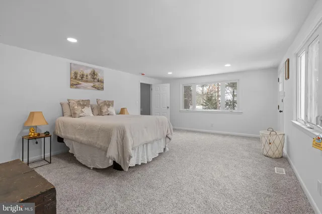 a spacious bedroom with a bed and a window