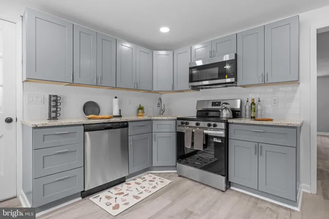 a kitchen with stainless steel appliances granite countertop a stove a sink and a microwave