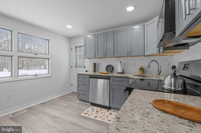a kitchen with granite countertop a sink cabinets and appliances