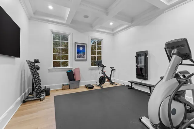 a dining room with wooden floor a chandelier a wooden table and chairs