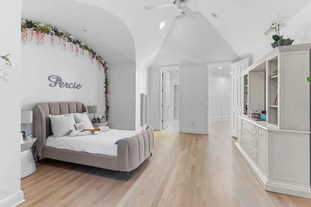a front view of a house with fountain plants and large tree