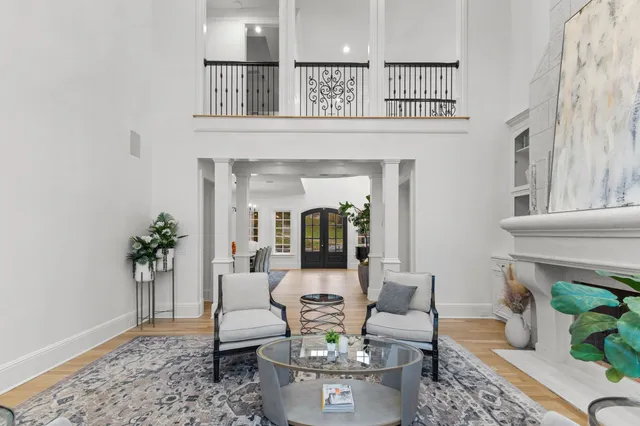 a living room with furniture kitchen view and a chandelier