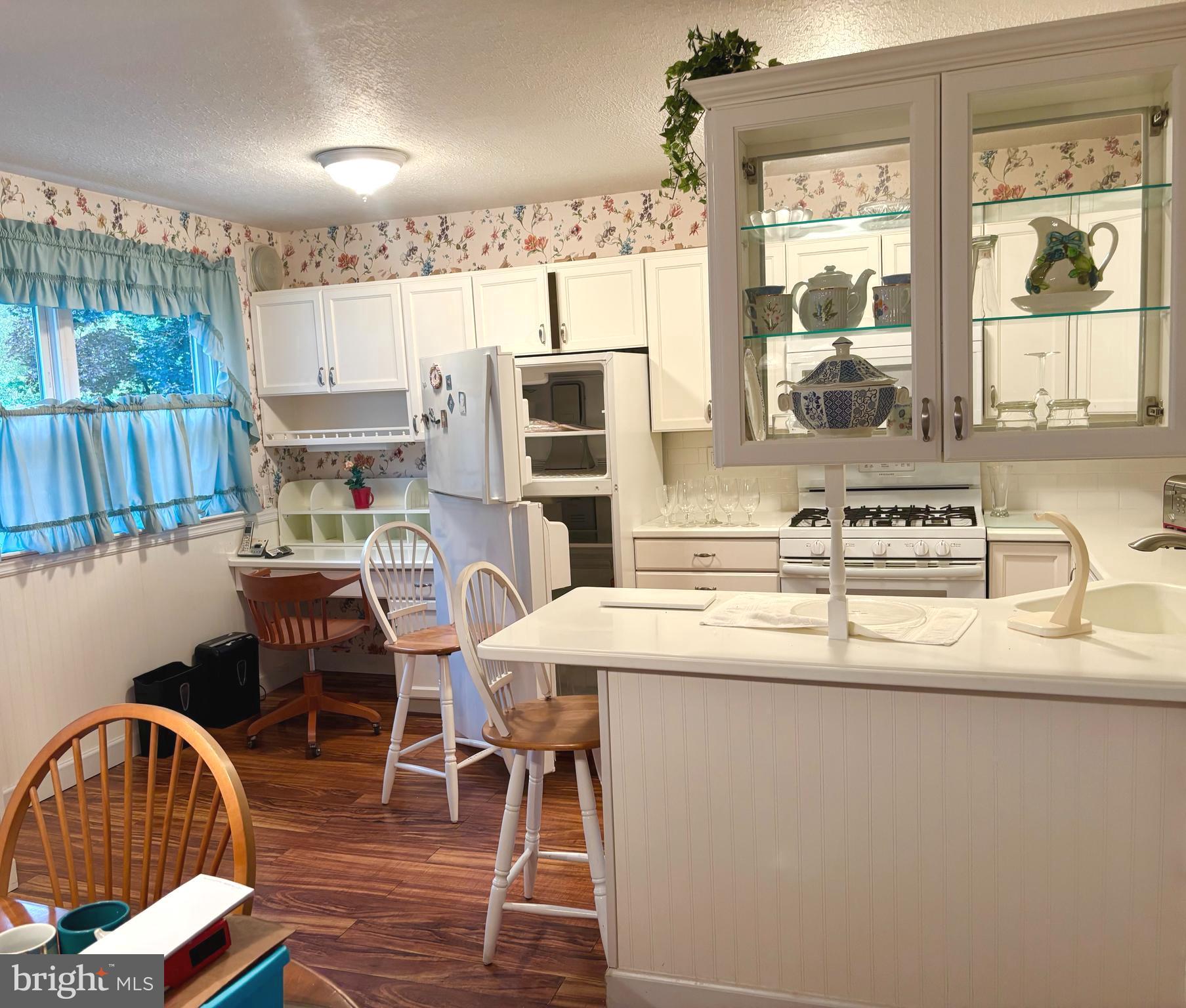 12517 Ramer Road Philadelphia, PA 19154 - Photo 7 of 24 a kitchen with stainless steel appliances granite countertop a sink a stove a dining table and chairs with wooden floor